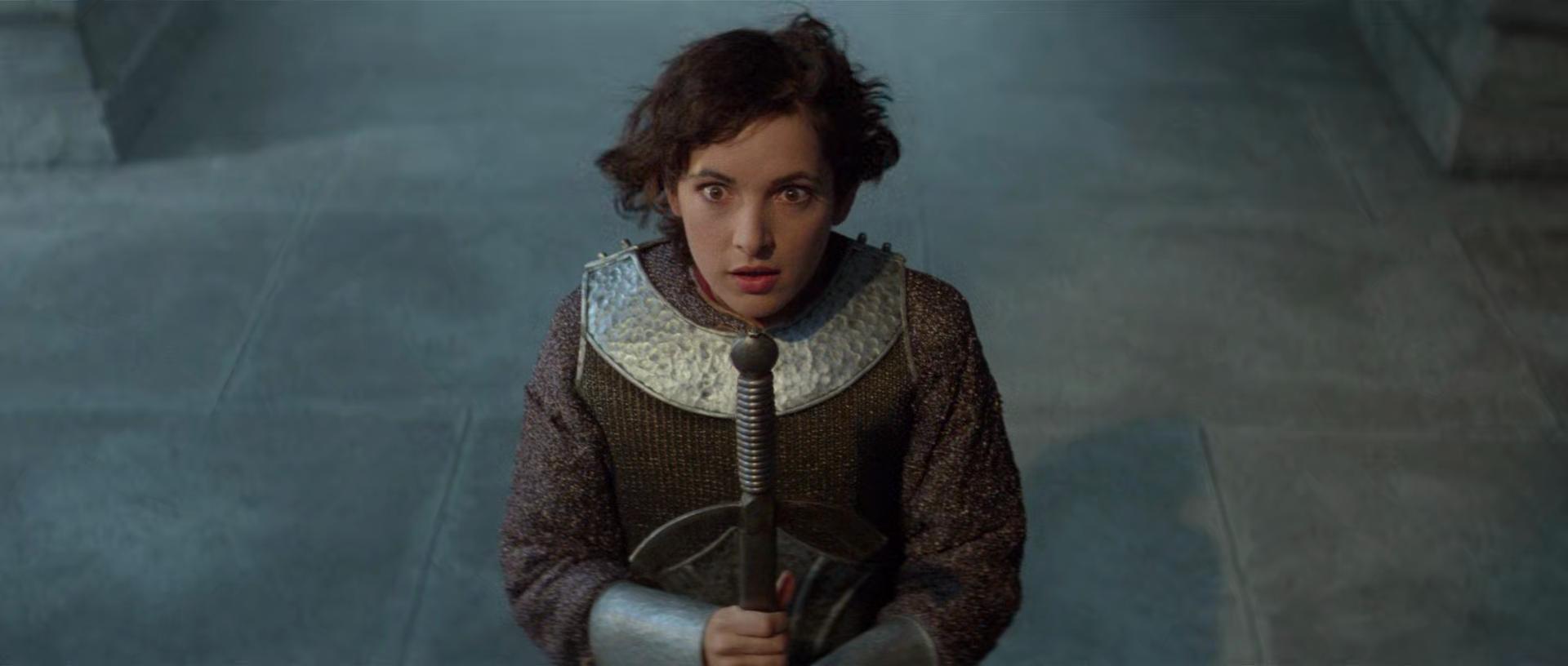 Jane Wiedlin as Joan of Arc kneeling with her sword in a church. From Bill & Ted's Excellent Adventure.