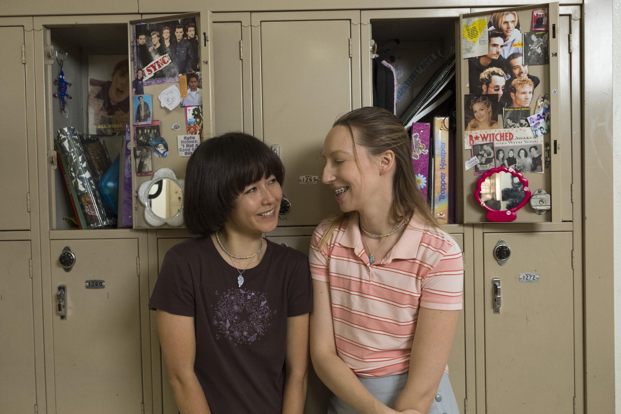 From PEN15: Maya Erskine and Anna Konkle leaning against a row of school lockers.