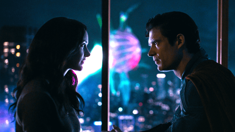 Superman (2025) Lois Lane and Kal-El/Clark Kent share a moment in her darkened apartment while the Justice Gang fights an interdimensional imp outside.
