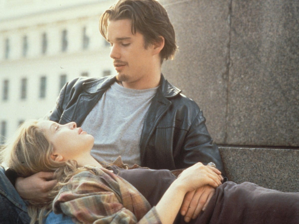 Before Sunrise: Celine reclines in Jesse's lap, looking up at him while sitting outside in Vienna.