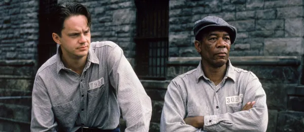 From The Shawshank Redemption: two prisoners sit side-by-side in a prison yard