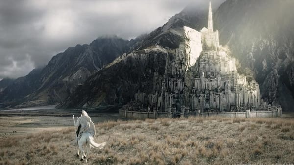 A white wizard (Gandalf) rides a horse towards a large white city on the side of a mountain