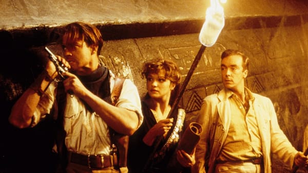 Inside an Egyptian tomb. Brendan Fraser holds a pistol, Rachel Weisz holds a torch, John Hannah holding his breath.