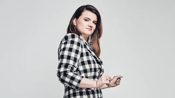 Leslye Headland stands in a black and whit checked blazer