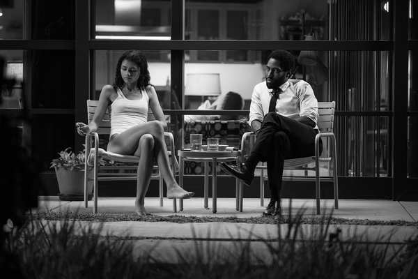 Zendaya and John David Washington sit across from each other in a scene from Malcolm & Marie