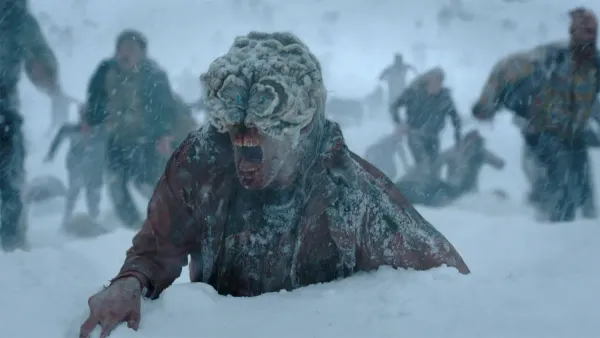 A zombie snarls in the snow in a scene from The Last of Us