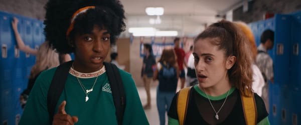 Ayo Edebiri and Rachel Sennott stand in a high school hallway in a still from Bottoms