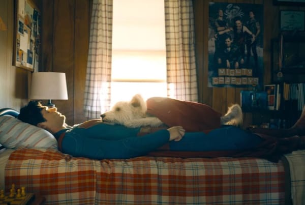 Superman (2025) Kal-El/Clark Kent lies down in his childhood bedroom with Krypto flopped on top of him, being a very good boy.