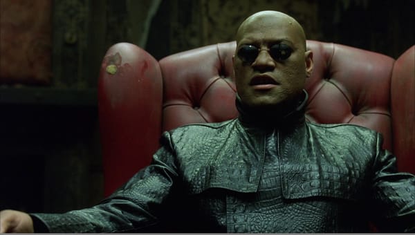 The Matrix: Morpheus sits in a red leather chair, talking about The Matrix and looking super cool.