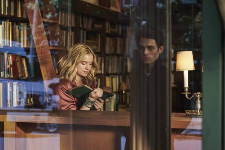 A man stares at a woman through a window in a still from Netflix's You