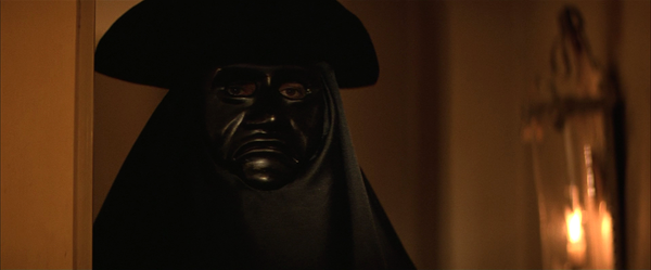 Amadeus: Salieri stands at Mozart's door wearing a black mask of death.