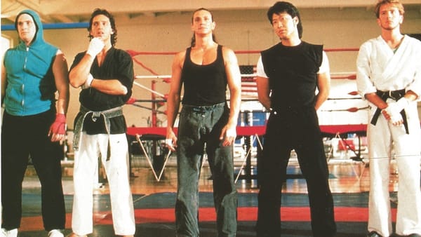 Screenshot from 1989's Best of the Best with an unlikely team of five martial arts guys standing in a row inside a gym.